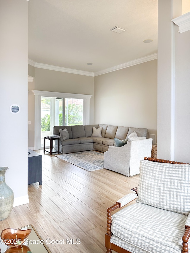 living room with ornamental molding and light hardwood / wood-style floors