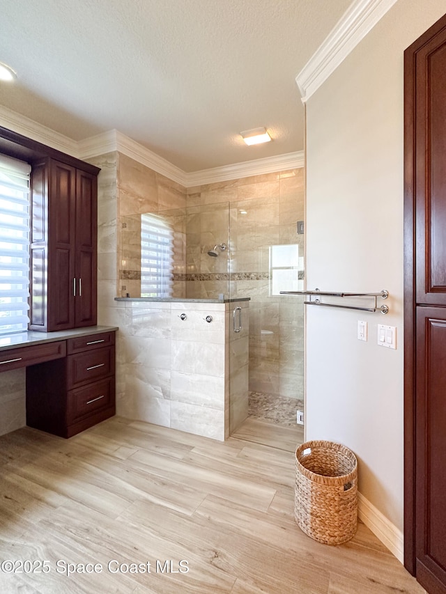 bathroom with walk in shower, ornamental molding, and a textured ceiling