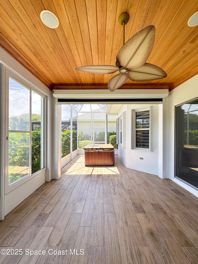 unfurnished sunroom featuring wood ceiling and ceiling fan