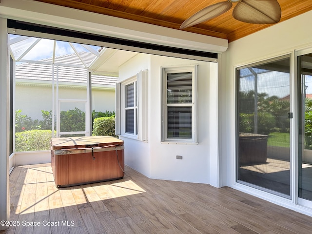 unfurnished sunroom with a hot tub and wooden ceiling