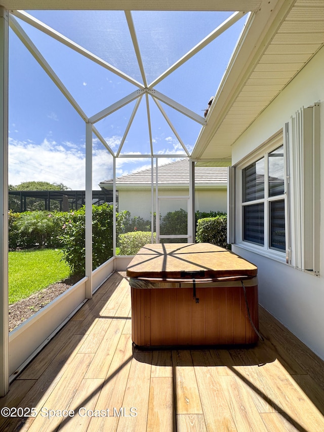 unfurnished sunroom with a hot tub