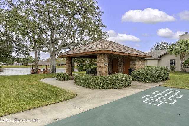 view of property's community with a gazebo, a water view, and a yard