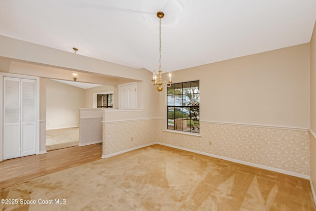 unfurnished dining area featuring carpet floors and a chandelier