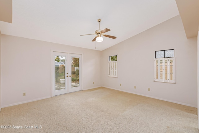 carpeted spare room with high vaulted ceiling, ceiling fan, and french doors