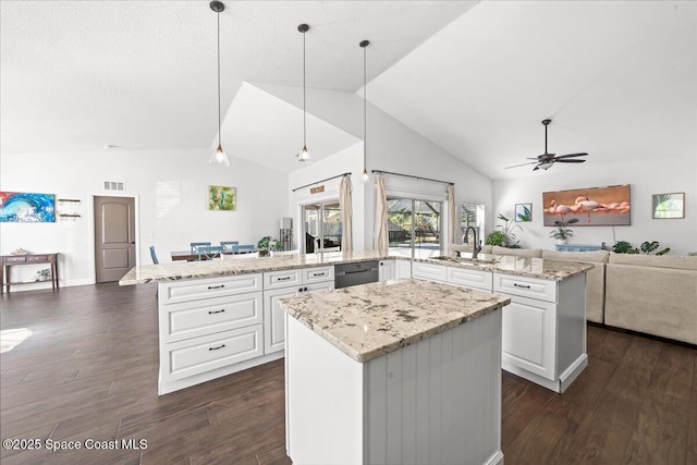 kitchen featuring kitchen peninsula, a center island, hanging light fixtures, and lofted ceiling