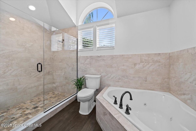 bathroom with hardwood / wood-style floors, separate shower and tub, toilet, and tile walls