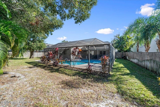 view of pool with a lawn and glass enclosure