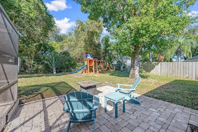 view of patio featuring a playground and a fire pit