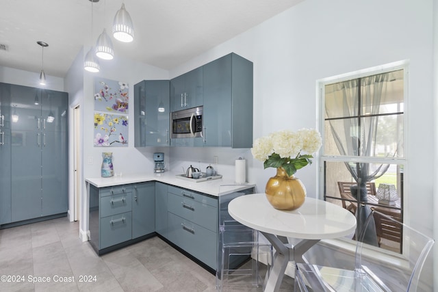 kitchen featuring decorative light fixtures, stovetop, blue cabinets, and light tile patterned floors