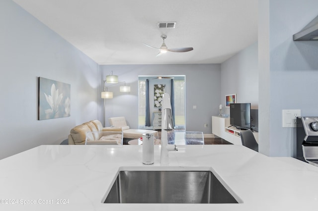 kitchen with ceiling fan, sink, and hanging light fixtures