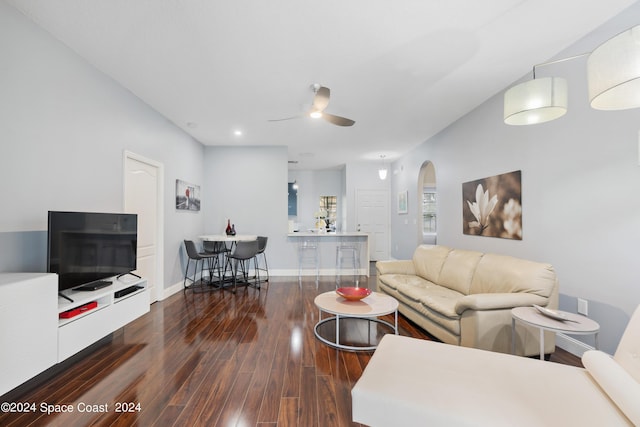 living room featuring ceiling fan and dark hardwood / wood-style flooring