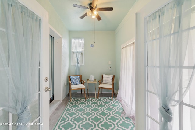 living area featuring ceiling fan and light hardwood / wood-style floors