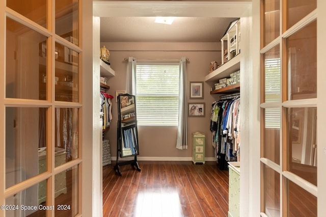 walk in closet with dark wood-type flooring