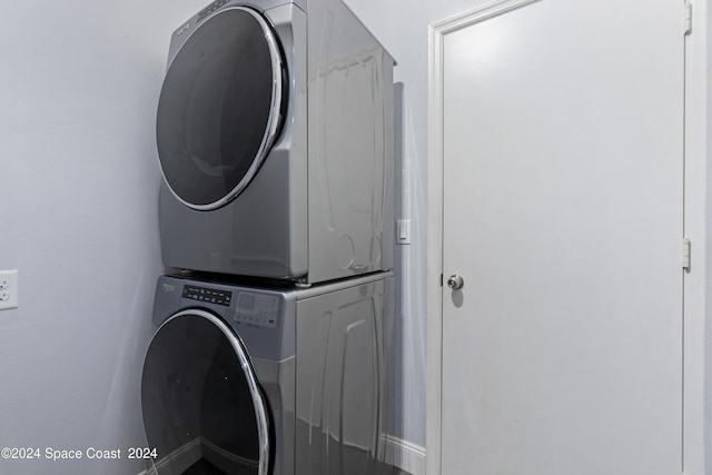 laundry room featuring stacked washer / drying machine