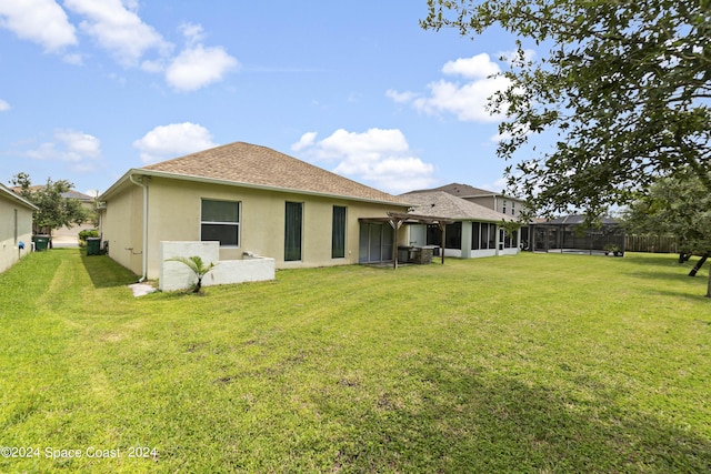 back of property featuring a lawn, a sunroom, and a pergola