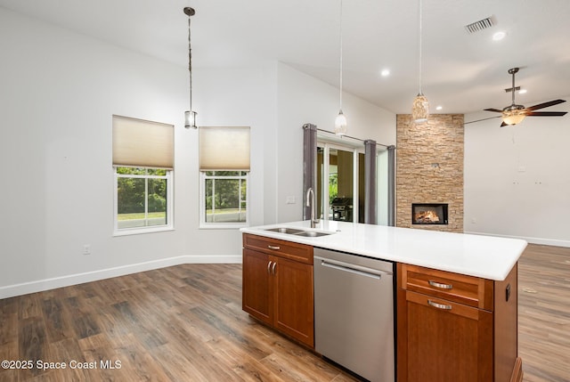 kitchen featuring stainless steel dishwasher, ceiling fan, a kitchen island with sink, sink, and pendant lighting