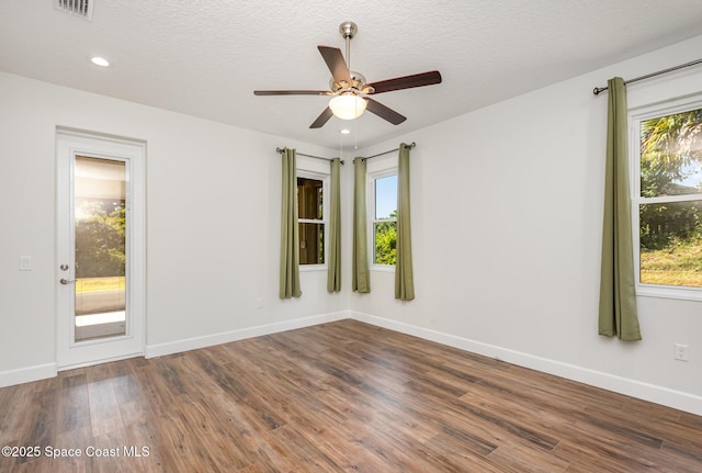 empty room featuring ceiling fan, wood-type flooring, and a textured ceiling