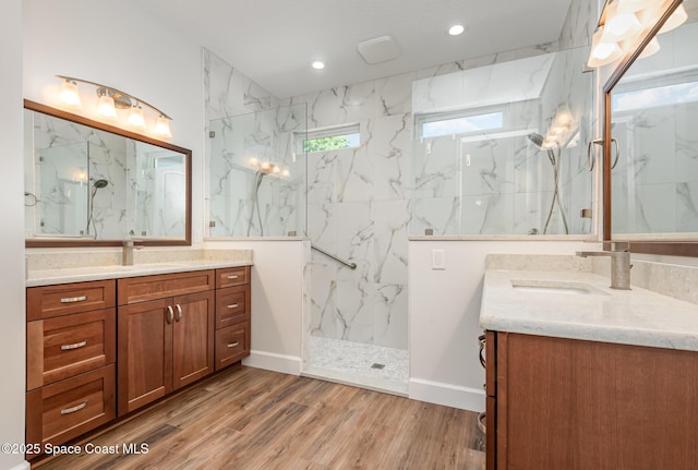 bathroom with vanity, wood-type flooring, and tiled shower