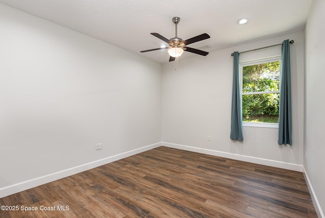 unfurnished room featuring ceiling fan and dark wood-type flooring