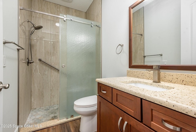 bathroom with toilet, vanity, hardwood / wood-style floors, and walk in shower