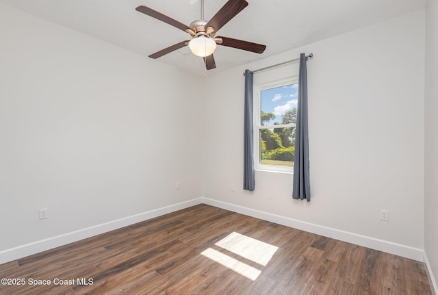 empty room with ceiling fan and dark wood-type flooring