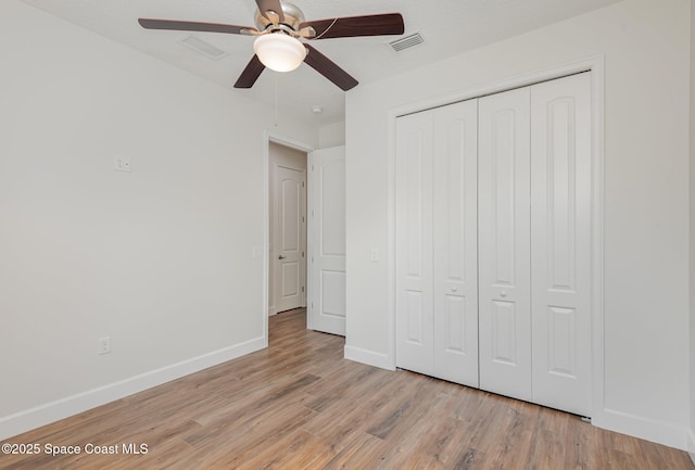 unfurnished bedroom featuring ceiling fan, light hardwood / wood-style floors, and a closet