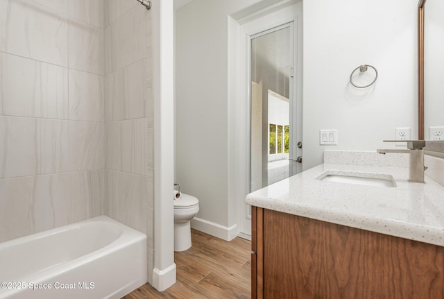 full bathroom with hardwood / wood-style floors, vanity, toilet, and  shower combination