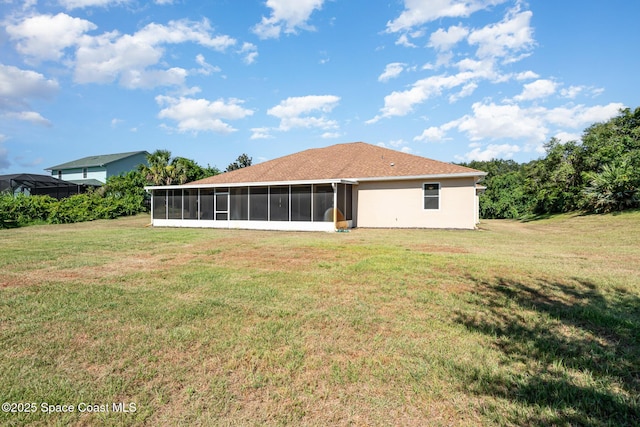 back of house featuring a sunroom and a lawn