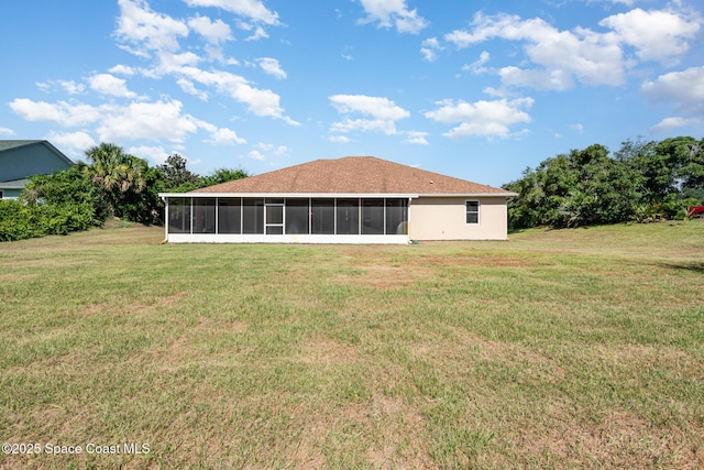 back of house featuring a sunroom and a lawn