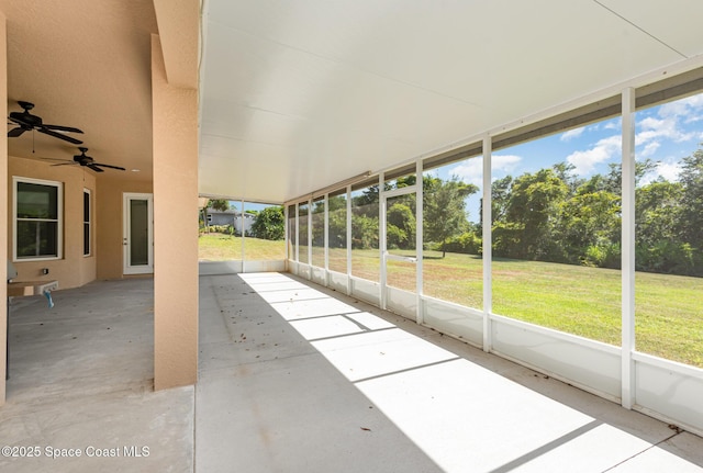 unfurnished sunroom with ceiling fan