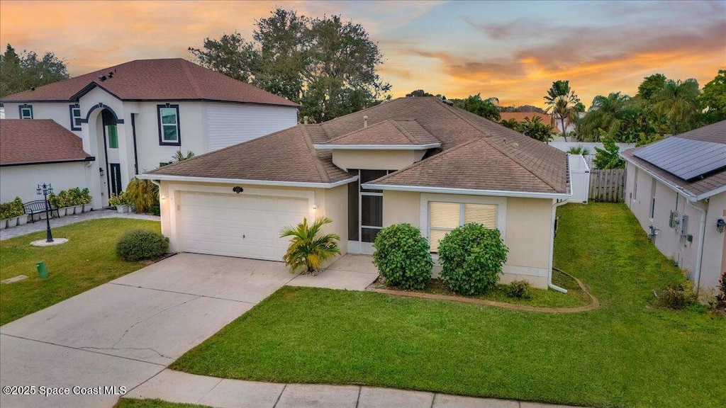 view of front facade featuring a garage and a yard