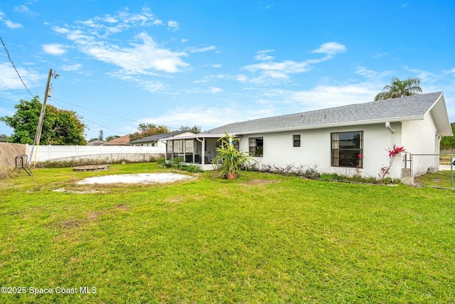 back of property with a yard and a sunroom