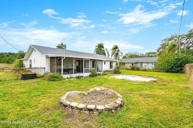 back of house with a lawn and a sunroom