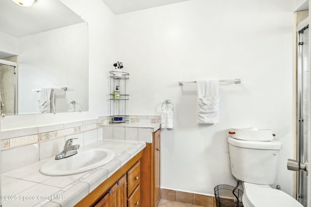 bathroom with tile patterned flooring, a shower with shower door, toilet, backsplash, and vanity