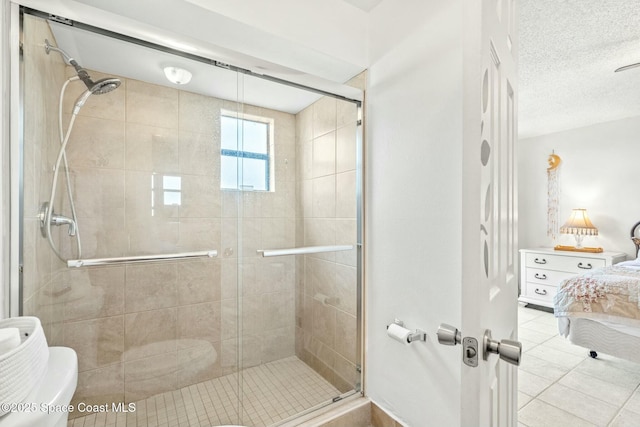 bathroom featuring a textured ceiling, an enclosed shower, tile patterned floors, and toilet