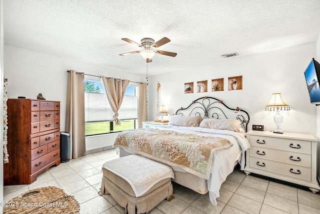 tiled bedroom featuring ceiling fan and a textured ceiling