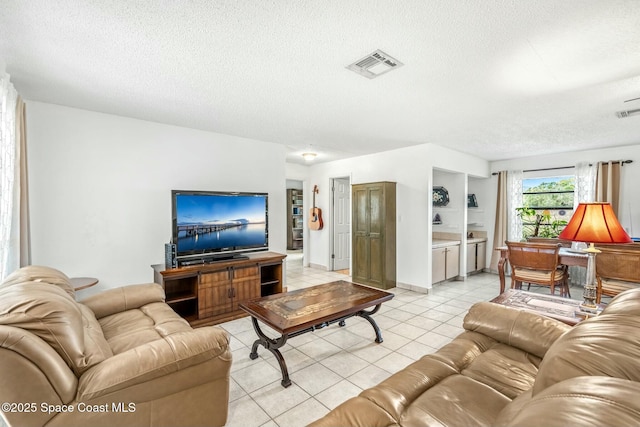 living room with a textured ceiling and light tile patterned floors