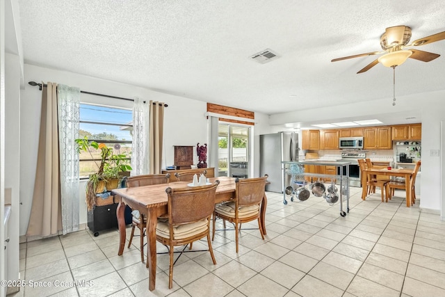 tiled dining space with ceiling fan