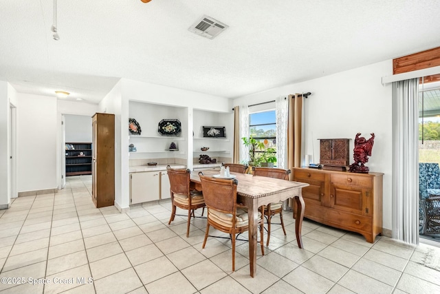 tiled dining area featuring a textured ceiling