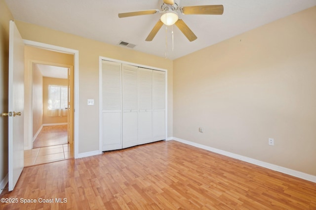 unfurnished bedroom with ceiling fan, light hardwood / wood-style flooring, and a closet