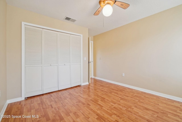 unfurnished bedroom with ceiling fan, light hardwood / wood-style floors, and a closet