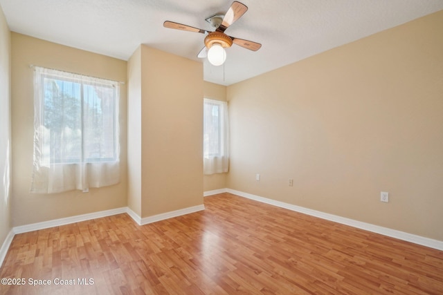 spare room with ceiling fan, light hardwood / wood-style flooring, and a wealth of natural light