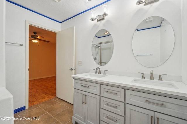 bathroom with a textured ceiling, ceiling fan, vanity, and tile patterned floors