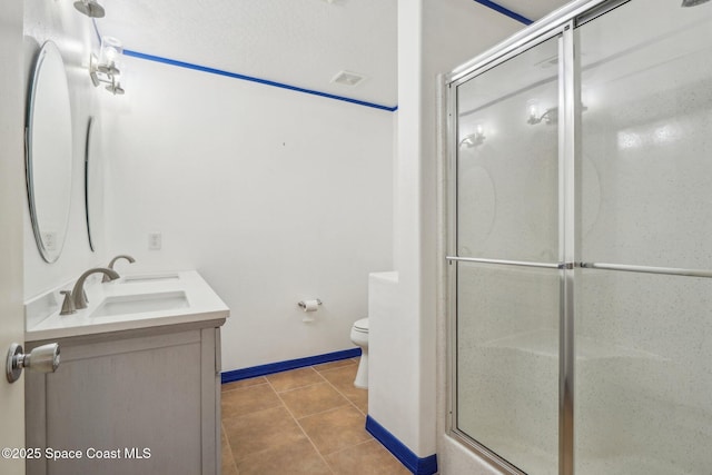 bathroom with vanity, tile patterned floors, a shower with shower door, and toilet