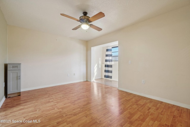 spare room featuring light wood-type flooring and ceiling fan