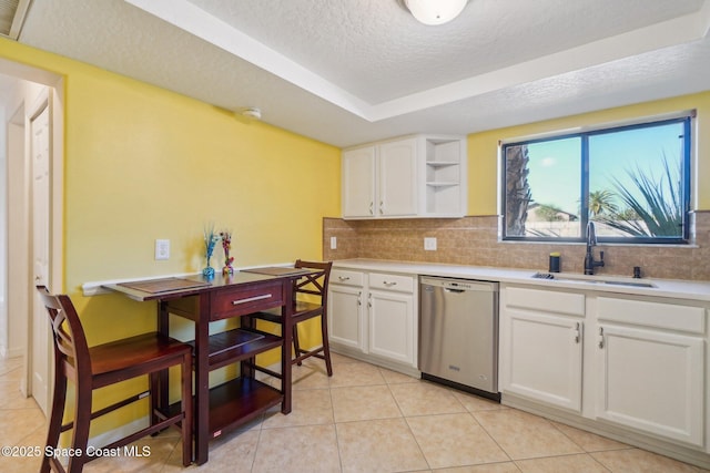 kitchen with stainless steel dishwasher, a textured ceiling, white cabinetry, light tile patterned flooring, and sink