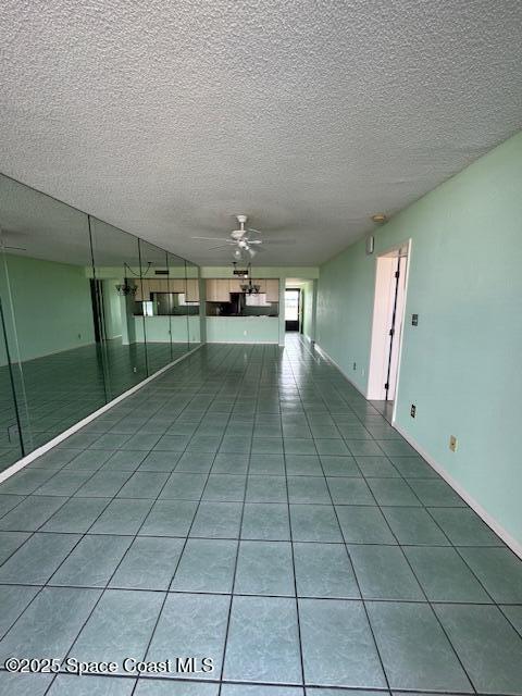 tiled empty room featuring a textured ceiling