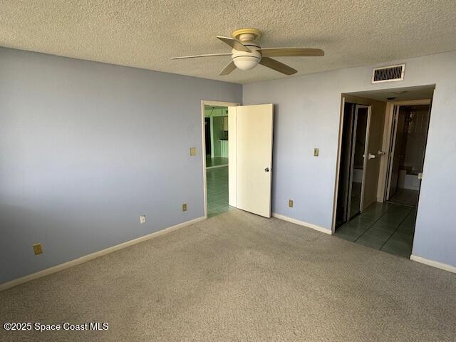 unfurnished bedroom with ceiling fan, carpet flooring, and a textured ceiling