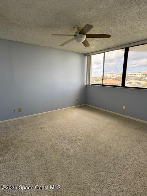 spare room with ceiling fan, carpet, and a textured ceiling