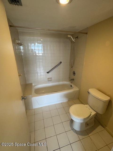 bathroom with tiled shower / bath, tile patterned floors, and toilet